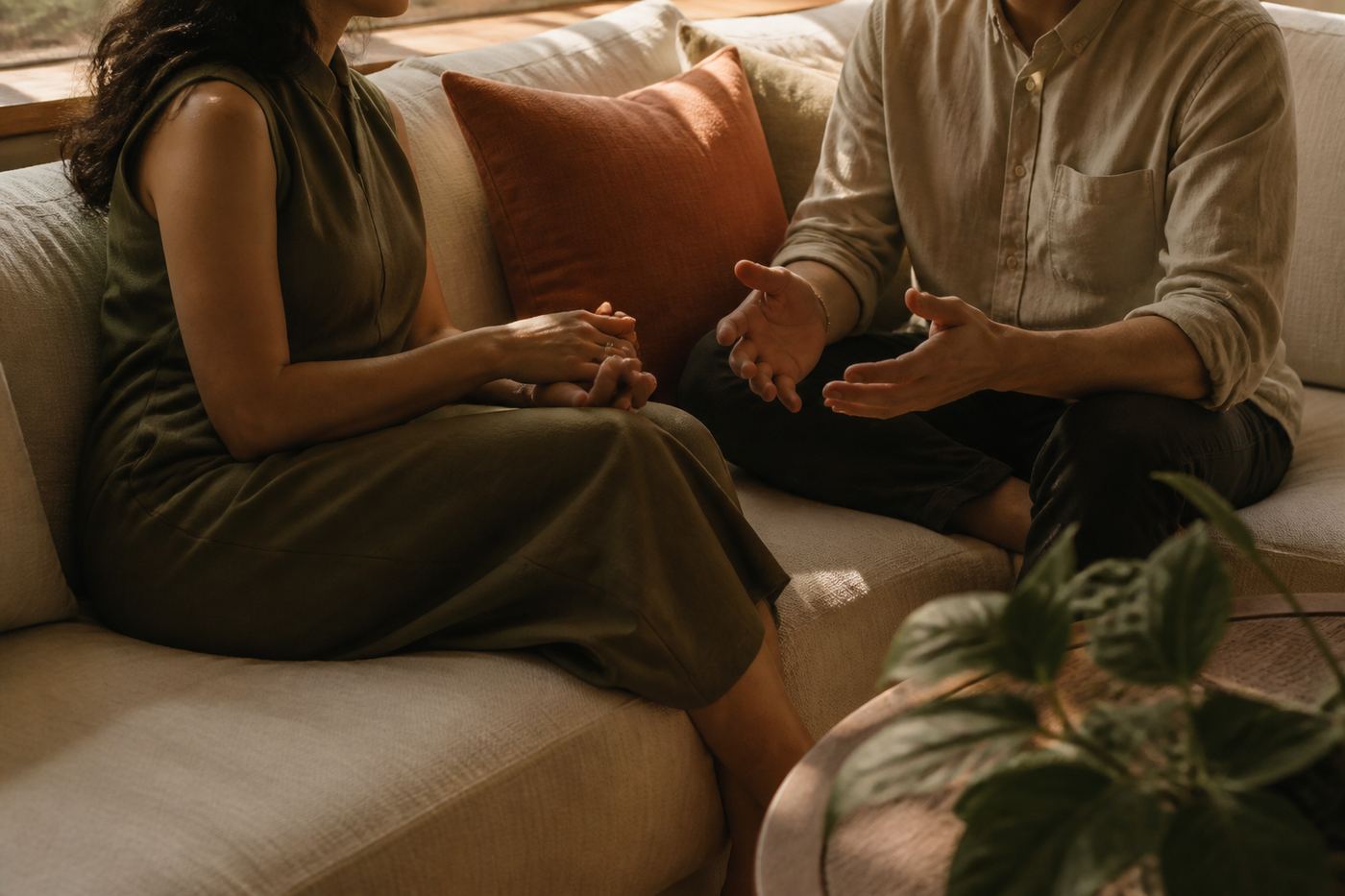 Two people in conversation on a linen sofa